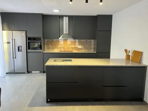 Kuzhinë antracit me ishull, pllakë pune nga graniti dhe frigorifer inoks